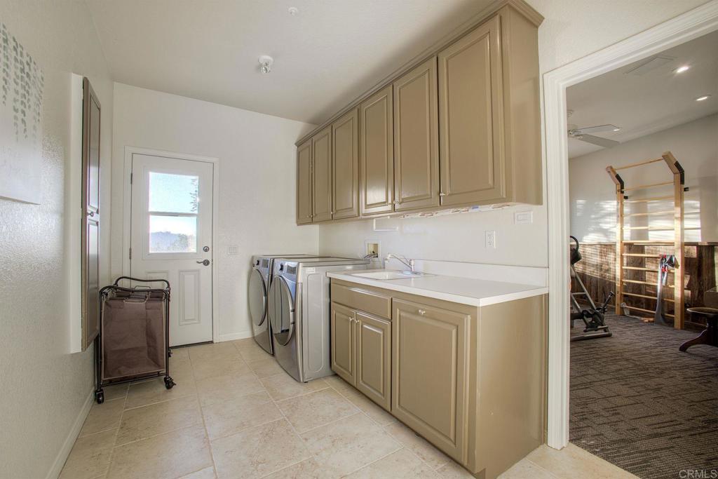 31220 Aquaduct Road Bonsall, CA 92003 - Photo 26 of 36 a utility room with cabinets washer and dryer