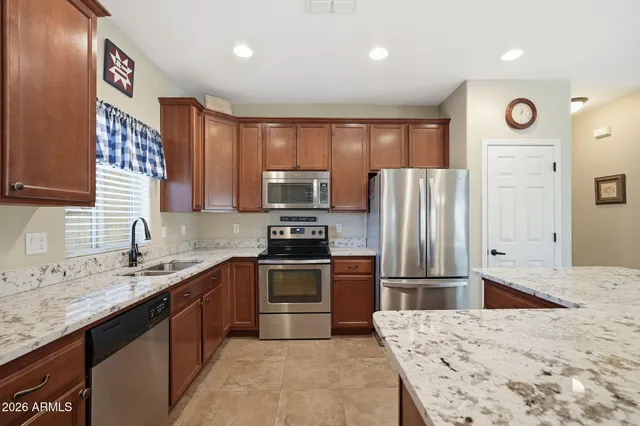 a kitchen with stainless steel appliances granite countertop a refrigerator sink and stove