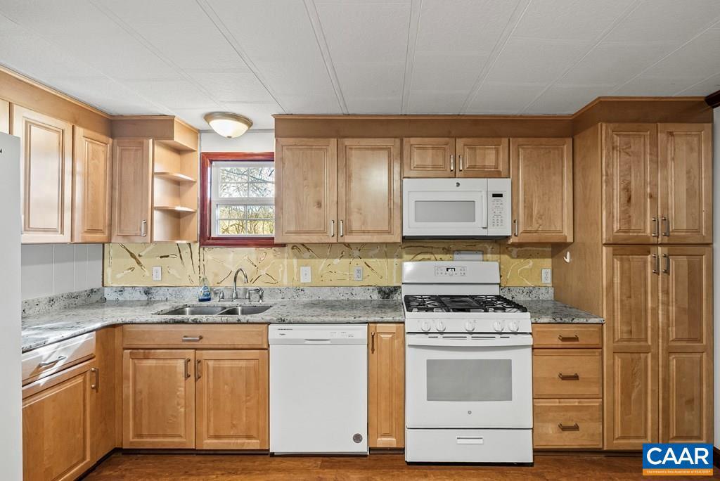1066 Stevens Cove Road Lovingston, VA 22949 - Photo 8 of 34 a kitchen with granite countertop a sink cabinets stainless steel appliances and a window