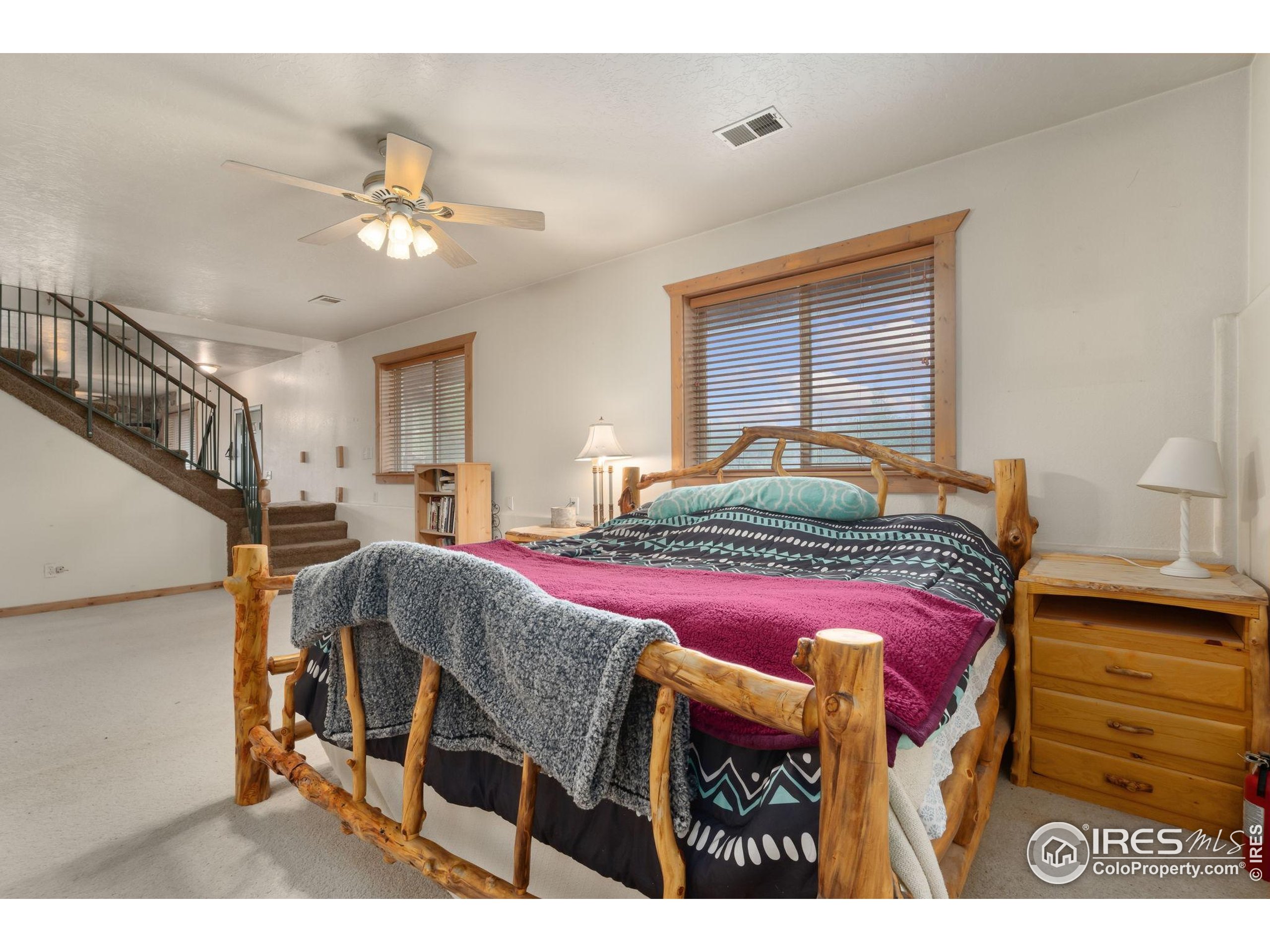 141 Tami Road Red Feather Lakes, CO 80545 - Photo 20 of 49 a bedroom with a bed and a chandelier