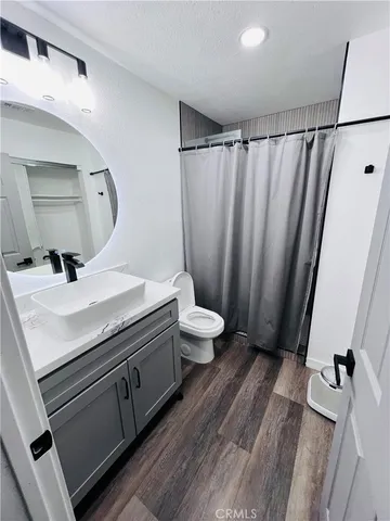 a bathroom with a sink a toilet a mirror and shower curtain