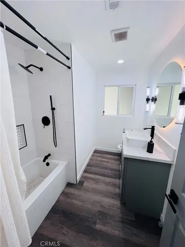 a bathroom with a bathtub a sink and mirror
