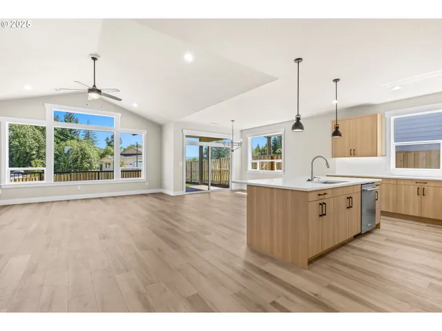 a kitchen with a wooden floor and windows