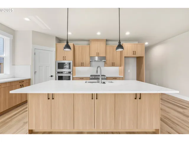 a kitchen with kitchen island a sink stove and refrigerator