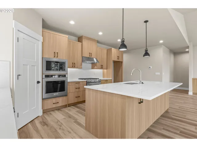 a kitchen with a sink a counter top space stainless steel appliances and cabinets