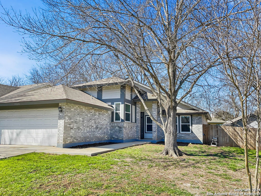 13211 Huntsman Road San Antonio, TX 78249 - Photo 1 of 33 a view of a yard in front of a house with large tree