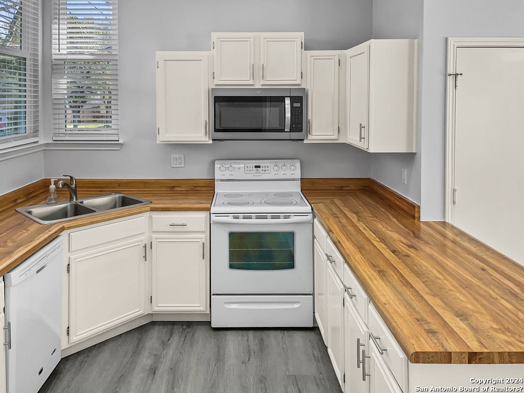 13211 Huntsman Road San Antonio, TX 78249 - Photo 12 of 33 a kitchen with granite countertop white cabinets and white appliances