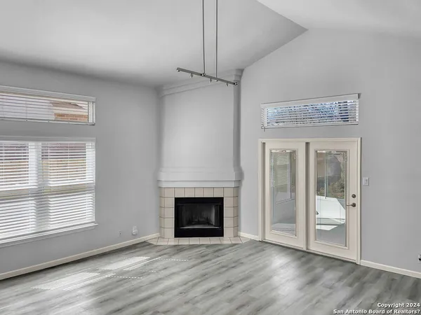 a view of an empty room with a fireplace and a window