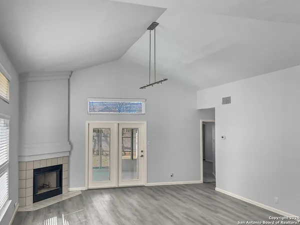 a view of empty room with wooden floor and fireplace
