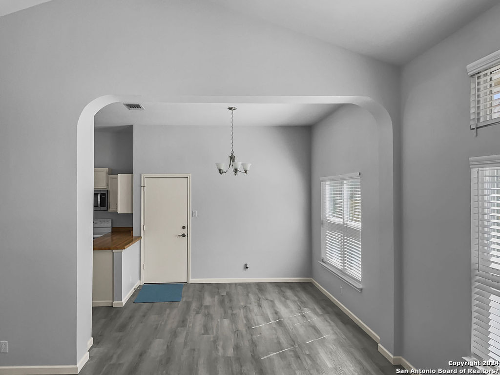 13211 Huntsman Road San Antonio, TX 78249 - Photo 8 of 33 wooden floor in an empty room with a window