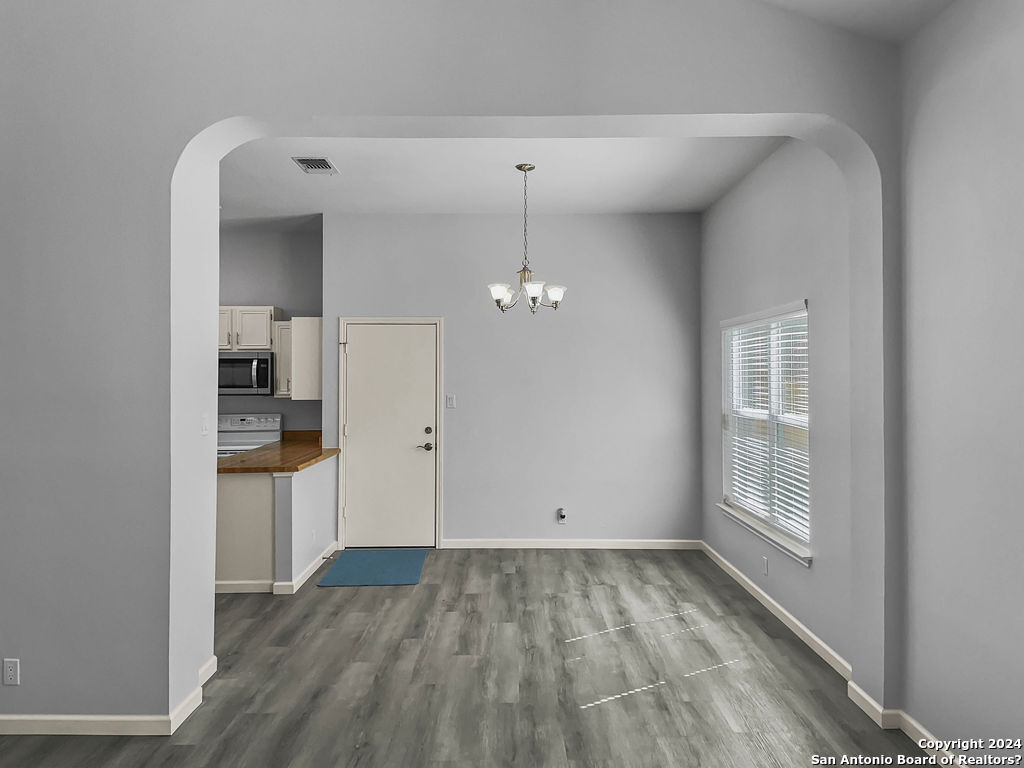 13211 Huntsman Road San Antonio, TX 78249 - Photo 10 of 33 wooden floor in an empty room with a window