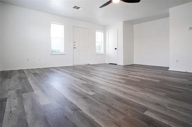 a view of an empty room with wooden floor