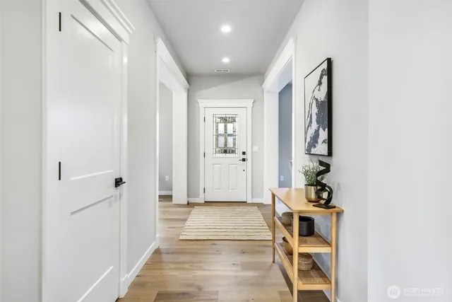 a kitchen with stainless steel appliances granite countertop a sink a stove a refrigerator and island with wooden floor