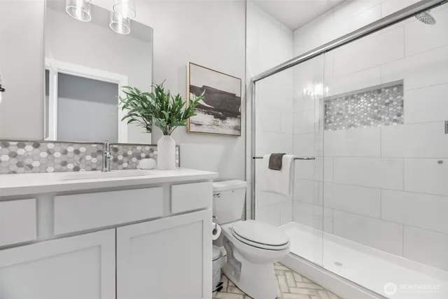 a bathroom with a sink a toilet and shower