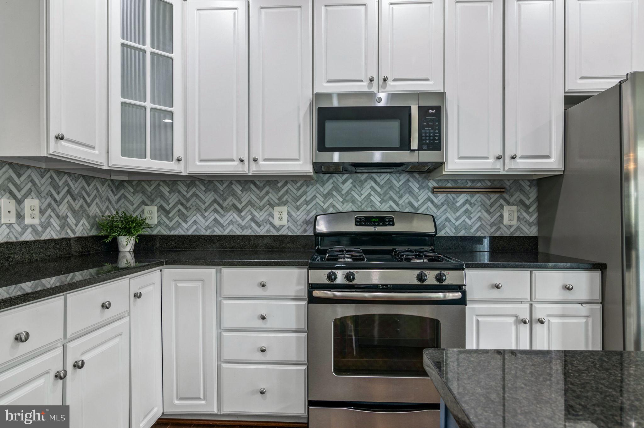 5893 Riverside Drive Woodbridge, VA 22193 - Photo 12 of 36 a kitchen with granite countertop white cabinets and stainless steel appliances