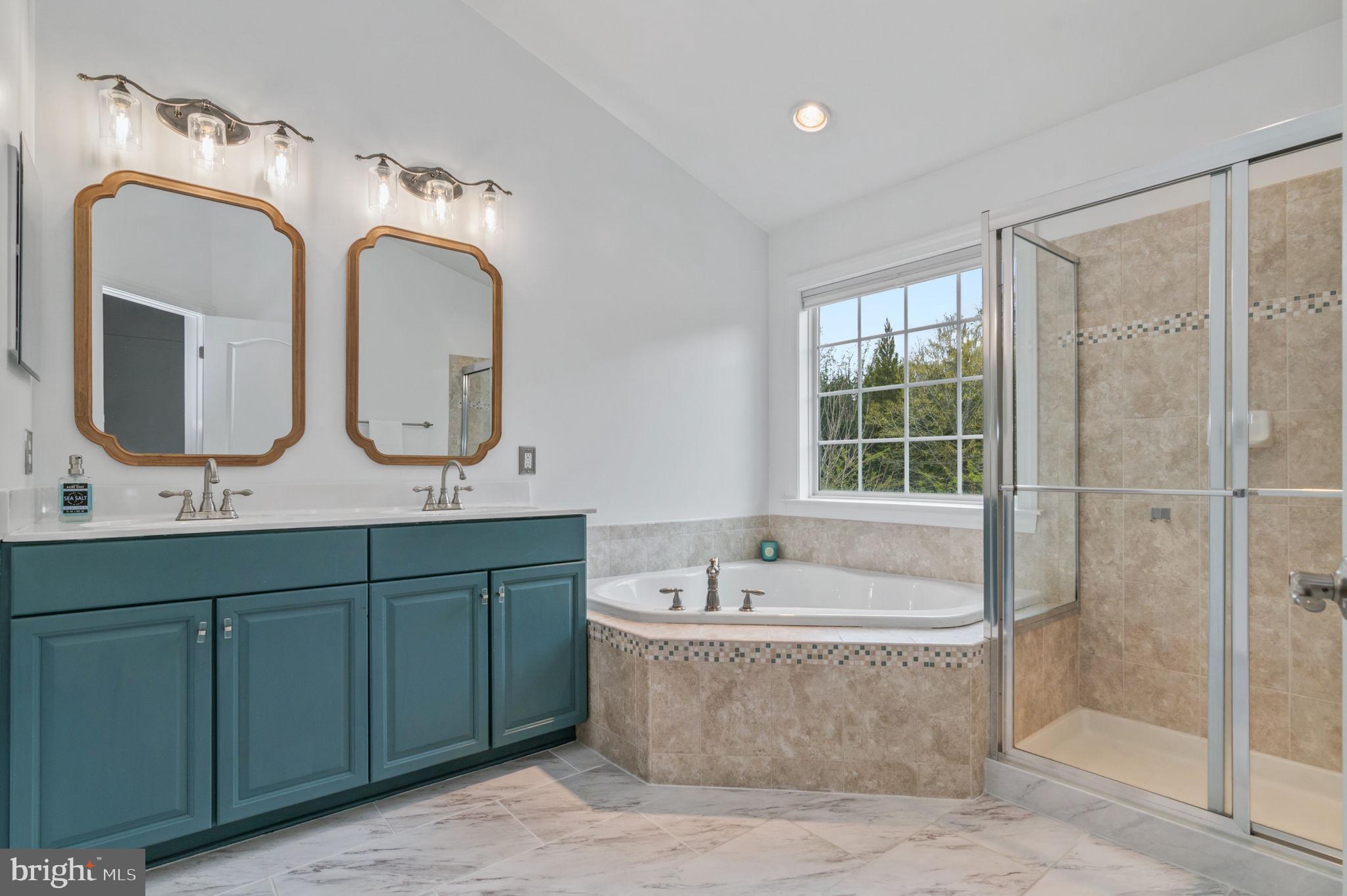 5893 Riverside Drive Woodbridge, VA 22193 - Photo 16 of 36 a spacious bathroom with double vanity sinks a mirror and a bathtub
