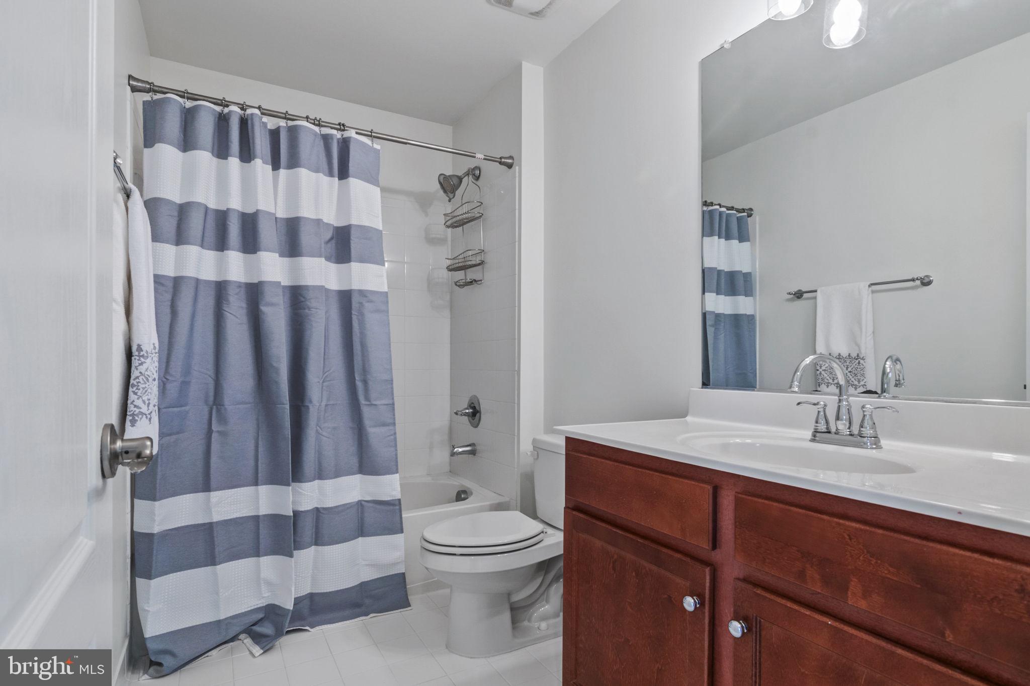 5893 Riverside Drive Woodbridge, VA 22193 - Photo 21 of 36 a bathroom with a sink a toilet a mirror and shower