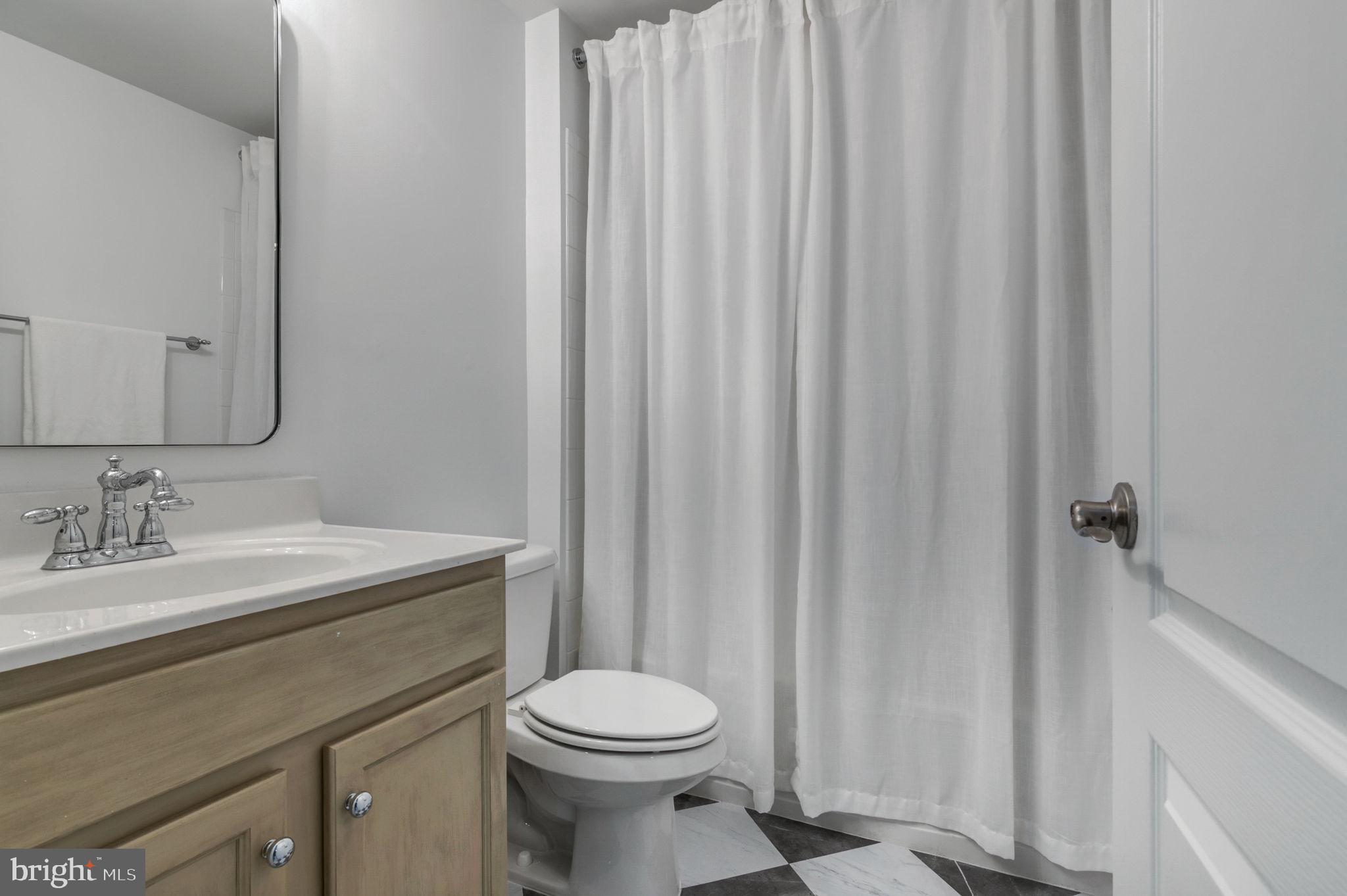 5893 Riverside Drive Woodbridge, VA 22193 - Photo 30 of 36 a bathroom with a sink a toilet and shower