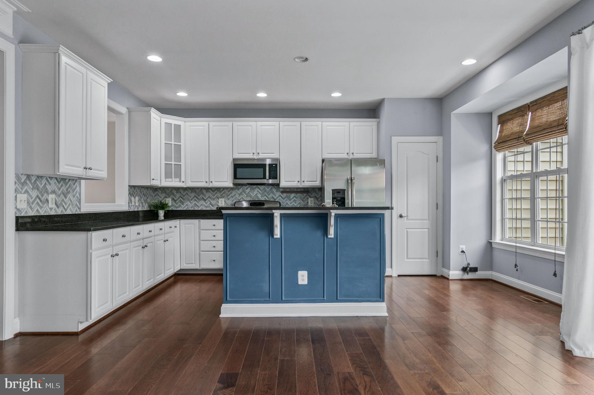5893 Riverside Drive Woodbridge, VA 22193 - Photo 9 of 36 a kitchen with stainless steel appliances granite countertop a refrigerator a stove a sink and white cabinets with wooden floor