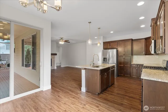 a large kitchen with stainless steel appliances kitchen island granite countertop a large counter top and wooden floors