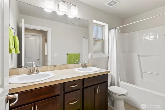 a bathroom with a sink a toilet a mirror and shower