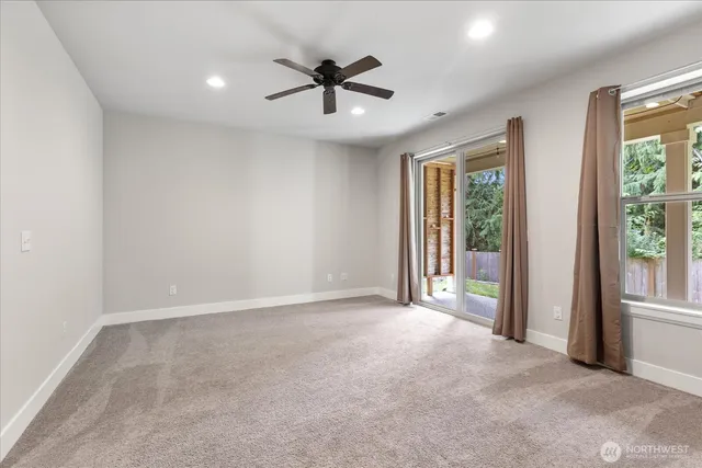 an empty room with closet and a ceiling fan