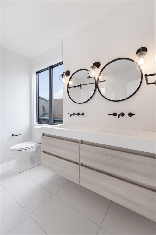 14 B Geneva Street, Unit 1 Boston, MA 02128 - Photo 3 of 4 a bathroom with a sink a toilet and a mirror