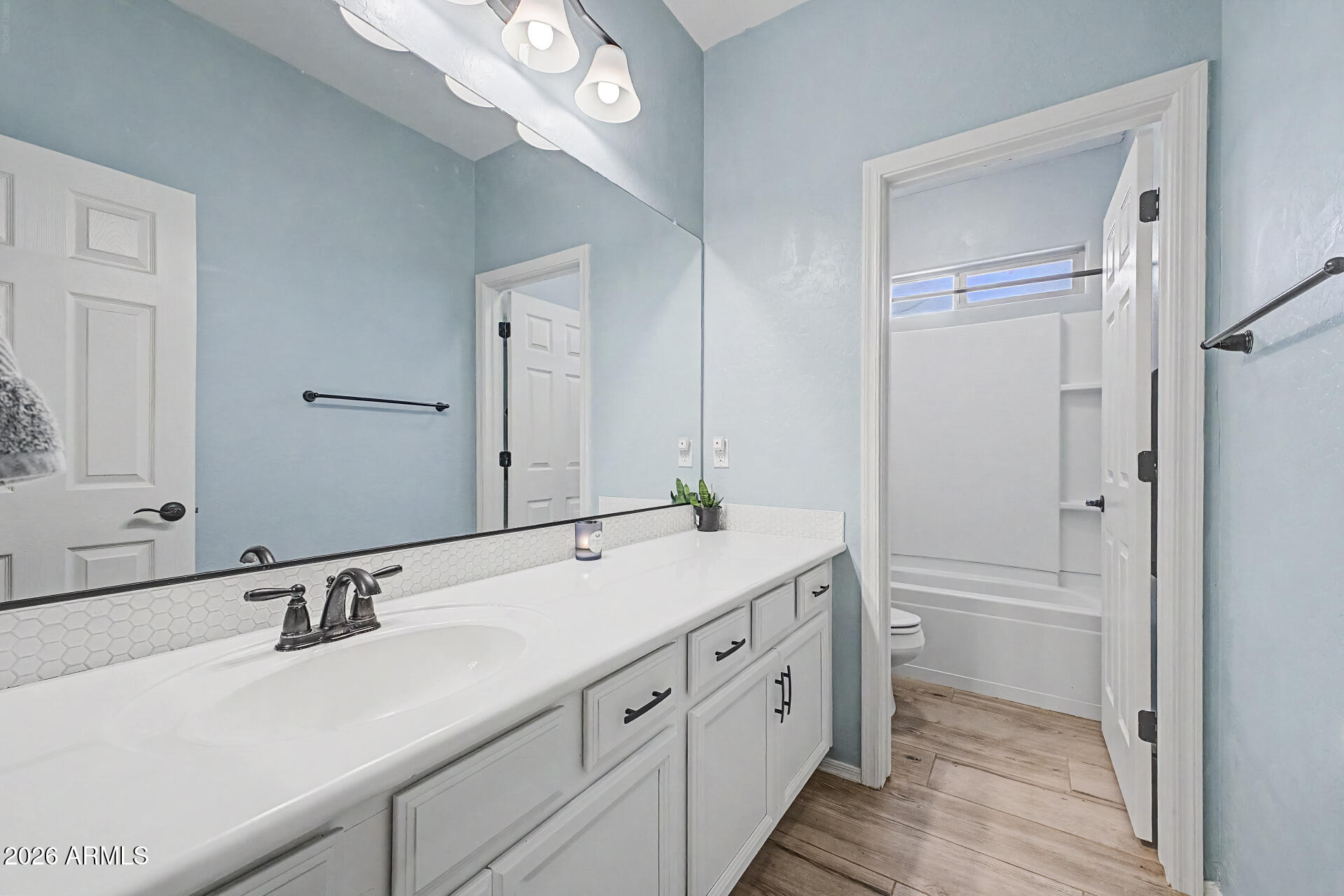 16719 West Rowel Road Surprise, AZ 85387 - Photo 18 of 28 a bathroom with a double vanity sink and mirror with shower