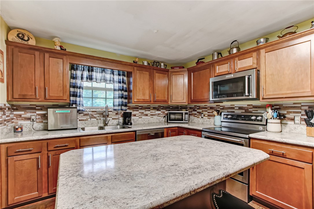 85091 Radio Avenue Yulee, FL 32097 - Photo 12 of 35 a kitchen with stainless steel appliances wooden cabinets a stove a sink and a microwave