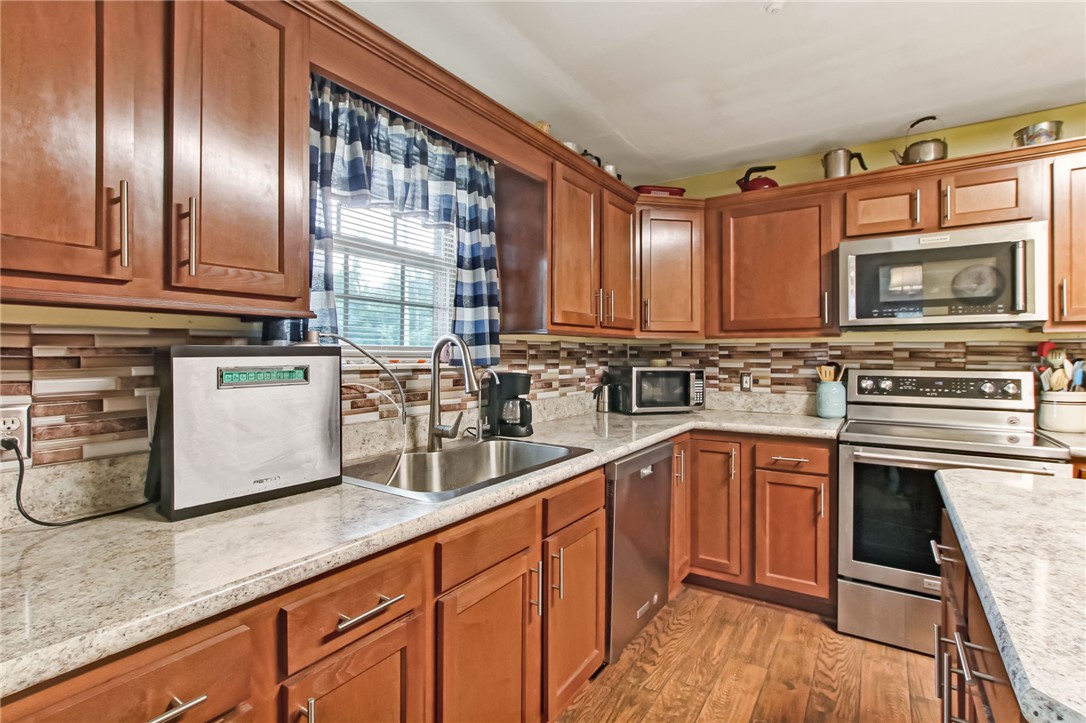 85091 Radio Avenue Yulee, FL 32097 - Photo 13 of 35 a kitchen with stainless steel appliances granite countertop a sink stove and cabinets
