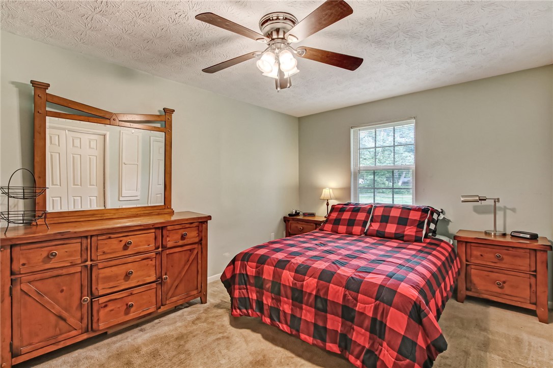 85091 Radio Avenue Yulee, FL 32097 - Photo 15 of 35 a bedroom with a large bed and a chandelier