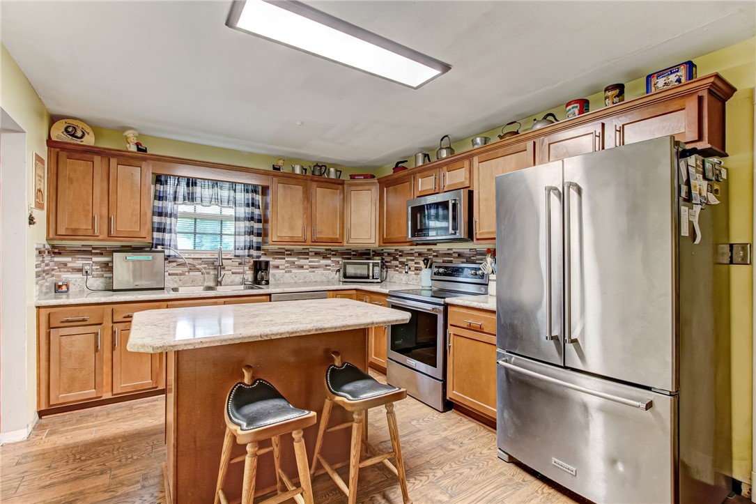 85091 Radio Avenue Yulee, FL 32097 - Photo 10 of 35 a kitchen with stainless steel appliances granite countertop a refrigerator a stove a sink and a microwave