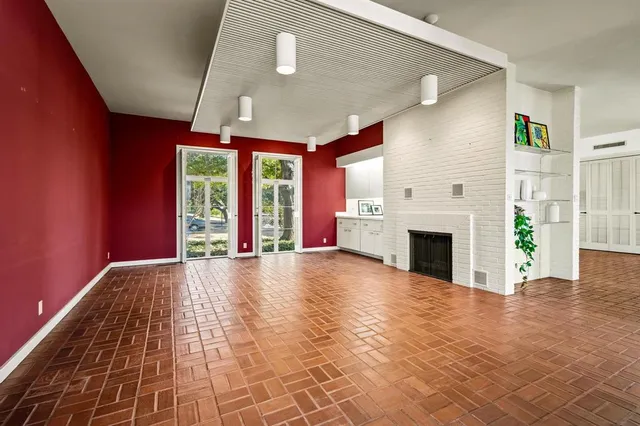 a view of empty room with fireplace and windows