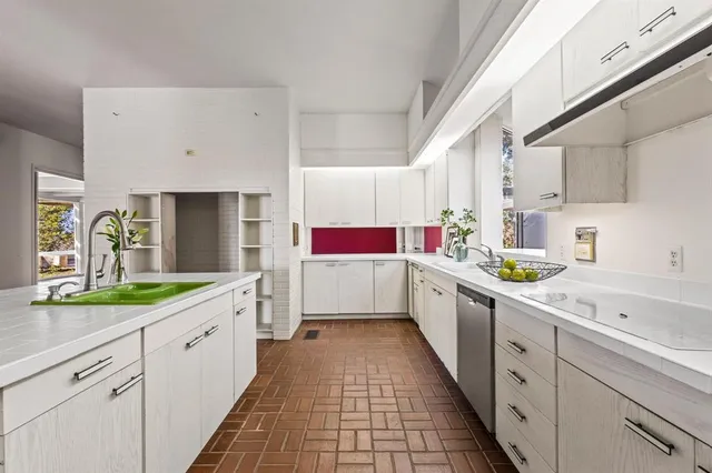 a white kitchen with a sink and white cabinets