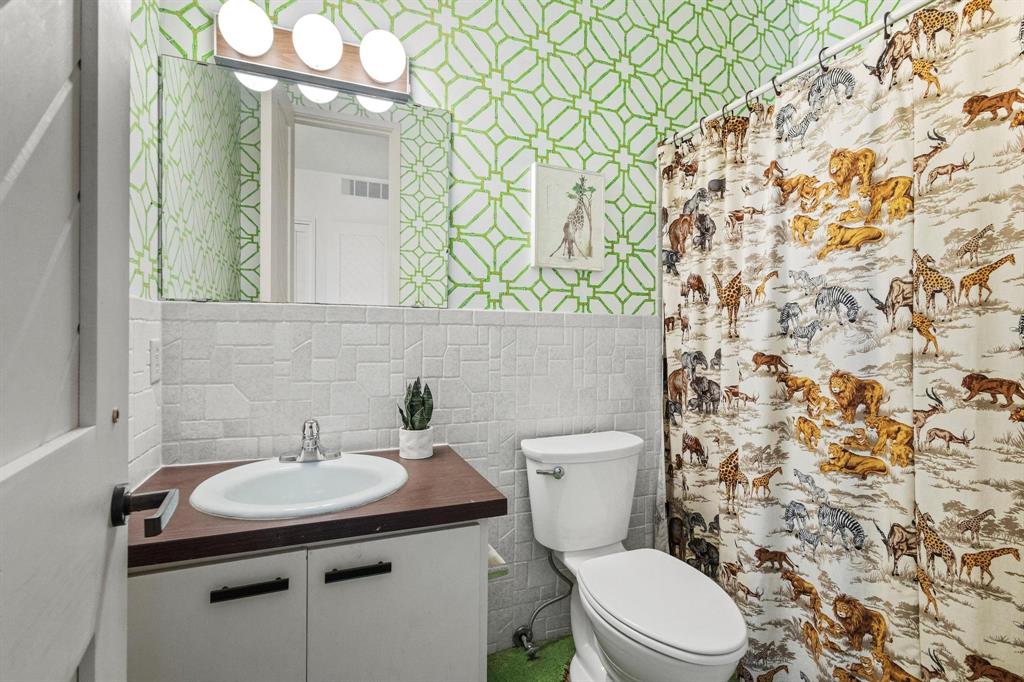 3906 Highland Drive Denison, TX 75020 - Photo 29 of 40 a bathroom with a sink a toilet and shower curtain