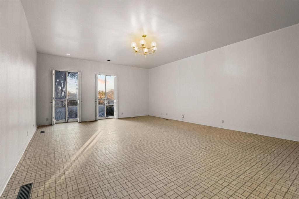 3906 Highland Drive Denison, TX 75020 - Photo 30 of 40 wooden floor in an empty room with a chandelier