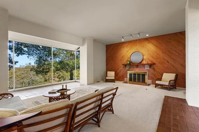 a living room with furniture and a floor to ceiling window