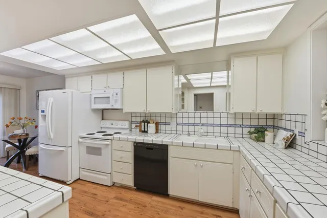 a kitchen with a sink cabinets stainless steel appliances and a window