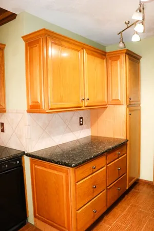 a view of granite countertop cabinets and window