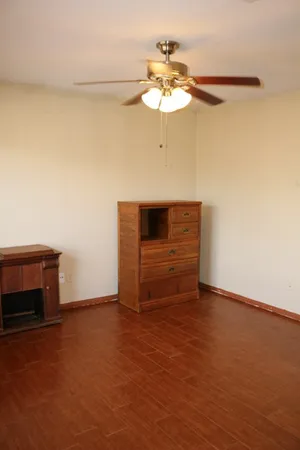 a view of an empty room with a chandelier fan