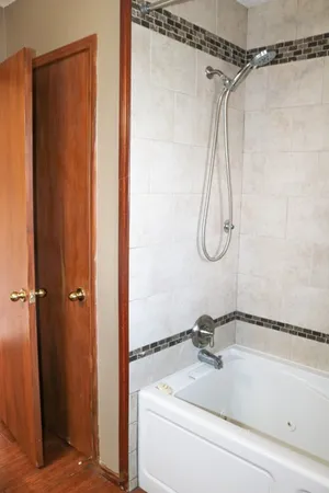 a bathroom with a bath tub with a shower