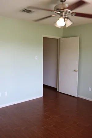 an empty room with a fan and a chandelier fan