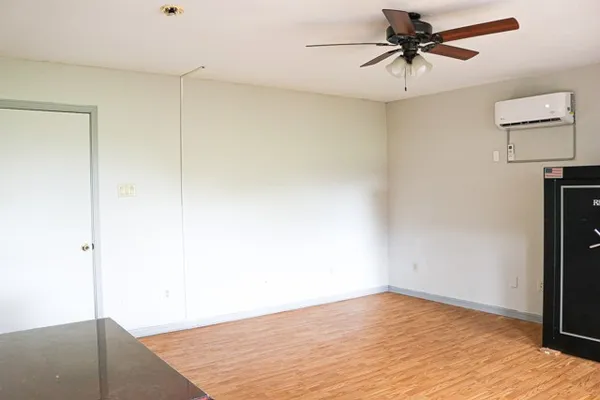 a view of empty room with wooden floor