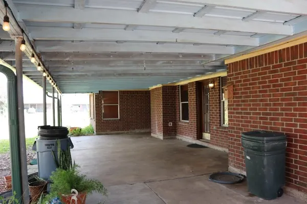 a view of a porch with furniture and floor to ceiling window