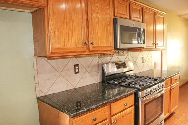 a kitchen with granite countertop a stove and a sink