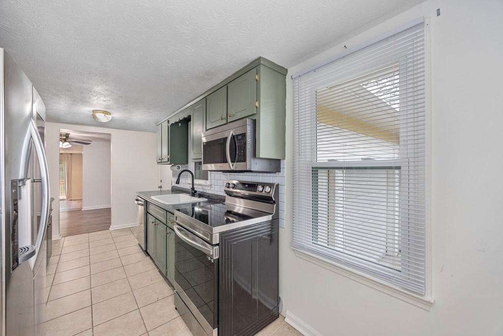 111 East Bon Acre Road Cataula, GA 31804 - Photo 5 of 16 a kitchen with stainless steel appliances granite countertop a stove a sink and a refrigerator