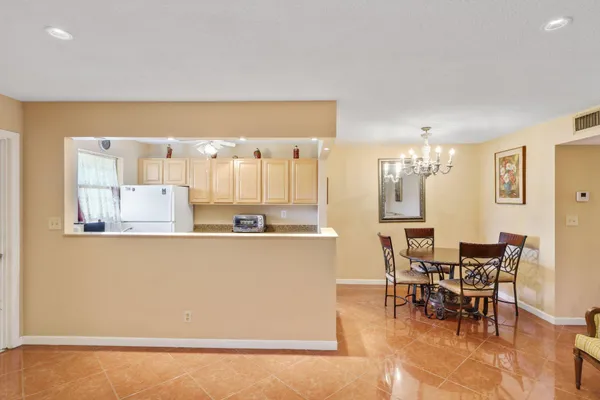 a kitchen with stainless steel appliances kitchen island granite countertop a table and chairs in it