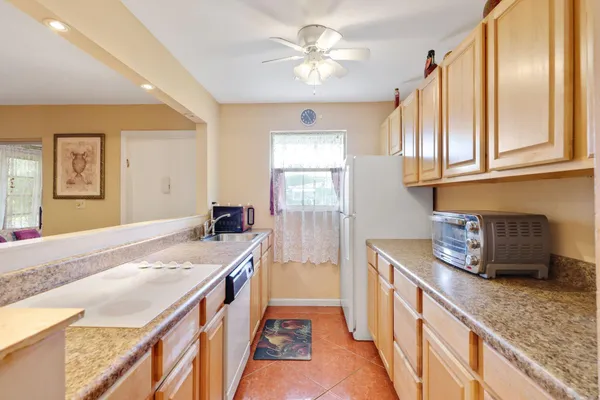 a kitchen with granite countertop a sink stove and cabinets