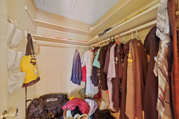 a view of walk in closet with clothes and shoes