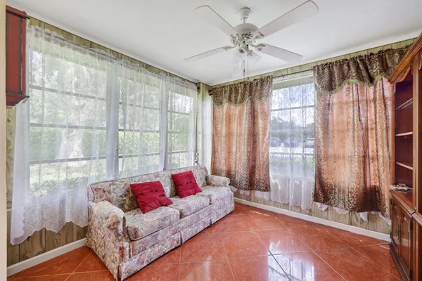 a living room with furniture and a floor to ceiling window